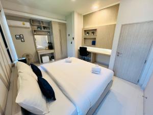 a bedroom with a large white bed with black pillows at Duangtham luxury Pool Villa in Ban Khlong Haeng