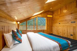 a bedroom with a bed in a wooden cabin at khwaab sojha in Alsindhi