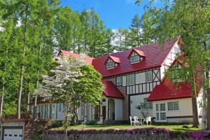a red and white house with a red roof at ray of hakuba 白馬の輝き in Hakuba