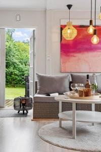 a living room with a coffee table and a painting at 1608-Melby-Elna-Lassensvej-10 in Melby