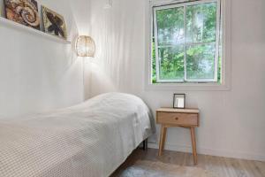 a white bedroom with a bed and a window at 1608-Melby-Elna-Lassensvej-10 in Melby