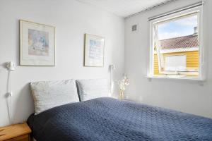 a bedroom with a blue bed and a window at 1484-N-Gilleleje-Markvaenget-11 in Gilleleje