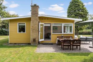 a small yellow house with a table and chairs at 1484-N-Gilleleje-Markvaenget-11 in Gilleleje +14 photos