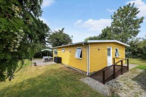 a yellow tiny house in the middle of a yard at 1484-N-Gilleleje-Markvaenget-11 in Gilleleje