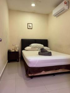 a bedroom with a bed with a white sheets and a phone at MN Ferringhi Inn in Batu Ferringhi