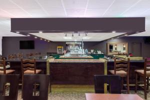 a bar in a restaurant with tables and chairs at Ramada by Wyndham Fresno North in Fresno