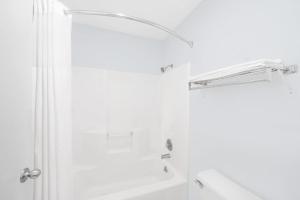 a white bathroom with a shower and a sink at Super 8 by Wyndham Van Horn in Van Horn +38 photos