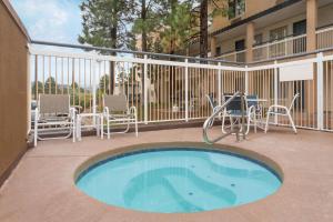a patio with a pool and chairs and a table at Baymont by Wyndham Flagstaff in Flagstaff