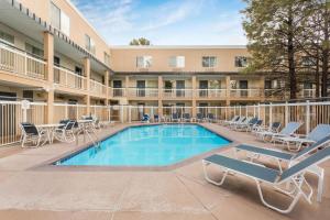 a swimming pool with lounge chairs and a hotel at Baymont by Wyndham Flagstaff in Flagstaff