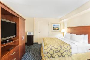 a hotel room with a bed and a flat screen tv at Baymont by Wyndham Flagstaff in Flagstaff