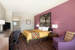 a hotel room with a bed and a desk and a chair at Super 8 by Wyndham Carrizo Springs in Carrizo Springs