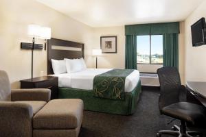 a hotel room with a bed and a desk and chairs at Baymont by Wyndham Glenwood in Glenwood +24 photos