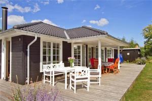 a house with a deck with a table and chairs at 902-N-Tisvildeleje-Klovervej-9 in Tisvildeleje