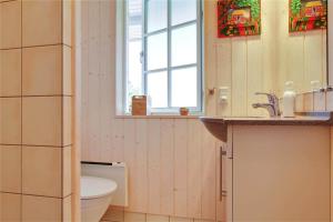 a bathroom with a toilet and a sink and a window at 902-N-Tisvildeleje-Klovervej-9 in Tisvildeleje +21 photos