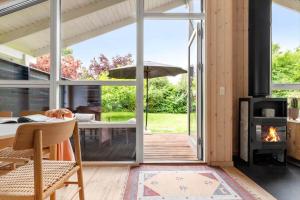 an open living room with a fireplace and a patio at 1497-N-Gilleleje-Parcelvej-3 in Gilleleje