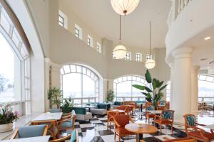 a restaurant with tables and chairs and windows at La Vie Dor Hotel and Resort, Trademark Collection by Wyndham in Hwaseong