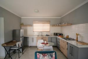 a kitchen with a table and a small table and chairs at Unit 4 at Homely Escapes in Phalaborwa