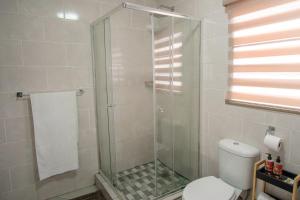 a bathroom with a glass shower with a toilet at Unit 4 at Homely Escapes in Phalaborwa