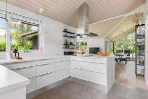 a kitchen with white cabinets and a large window at 1576-Liseleje-Korntoften-7 in Liseleje