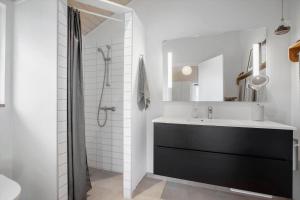 a white bathroom with a sink and a shower at 1576-Liseleje-Korntoften-7 in Liseleje +13 photos