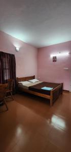 a bedroom with a large bed in a pink wall at Lakeview Meadows in Vagamon