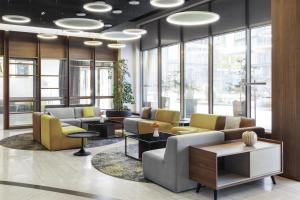 a lobby with couches and tables and windows at Doubletree by Hilton Ljubljana in Ljubljana