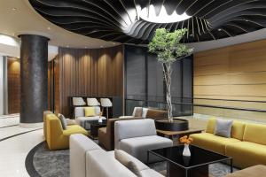 a lobby with couches and chairs and a potted tree at Doubletree by Hilton Ljubljana in Ljubljana