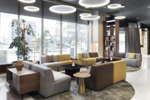 a lobby with couches and tables and large windows at Doubletree by Hilton Ljubljana in Ljubljana