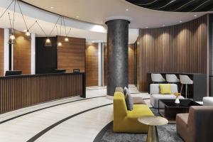 a lobby of a hotel with a yellow chair at Doubletree by Hilton Ljubljana in Ljubljana +90 photos