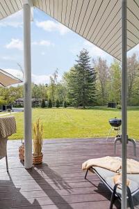 a patio with a grill and a field of grass at 1572-Melby-Kildegardsvej-10 in Melby