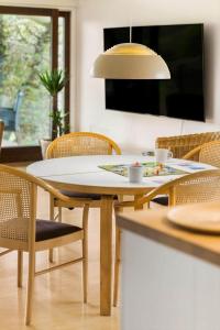 a dining table and chairs with a table and a lamp at 1566-Dronningmolle-Vipstjertvej-12 in Dronningmølle