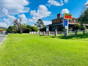 a sign for a motel on a green lawn at Kinross Inn in Cooma