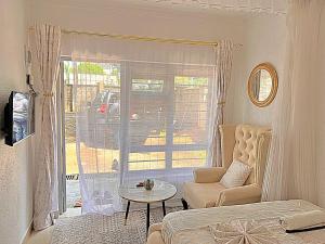 a living room with a couch and a table and a window at Luxury Homely Apt studio with pool in Kisumu +13 photos