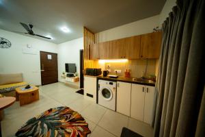 a kitchen with a washing machine in a room at Casa Luma 1BHK Furnished Siolim Swimming Pool Jacuzzi Sauna in Cunchelim