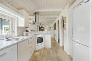 a white kitchen with a sink and a stove at 617-N-Melby-Bakkely-8-B in Melby