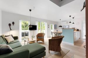 a living room with a green couch and a kitchen at 1602-Vejby-Brondsholmvej-33 in Vejby