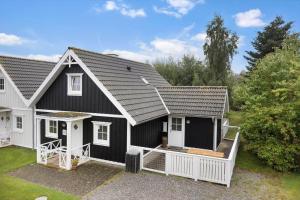 a black and white house with a porch at 1602-Vejby-Brondsholmvej-33 in Vejby