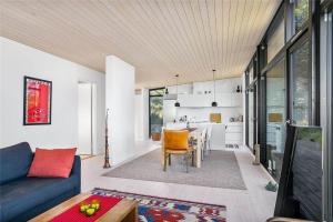 a living room with a blue couch and a kitchen at 1164-N-Melby-Bjergvej-7 in Melby