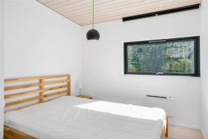a white bedroom with a bed and a window at 1164-N-Melby-Bjergvej-7 in Melby