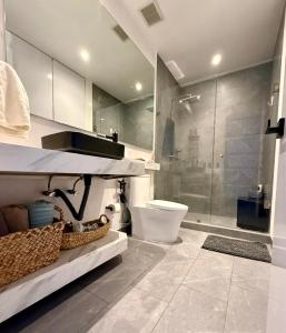 a bathroom with a toilet and a glass shower at Stylish Loft for 4 Reforma CDMX Ideal Long Stay in Mexico City +7 photos