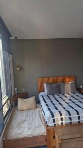 a bedroom with a bed with a blue and white checkered blanket at Stylish Loft for 4 Reforma CDMX Ideal Long Stay in Mexico City