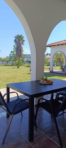 a table and chairs in a patio with a view of a field at Eden's Garden Kalamitsi in Kalamitsi
