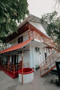 a house with a red and white at Marari Jackson Beach Homestay in Mararikulam