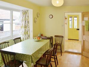 a dining room with a table with chairs and a green table cloth at The Castaway in Mundesley