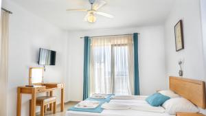a bedroom with a bed and a desk and a window at Otel Kefalos in Gokceada Town