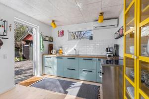 a kitchen with blue cabinets and a window at 1642-Hundested-Egernvej-1 in Hundested