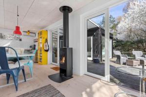 a fireplace in a living room with a table and a patio at 1642-Hundested-Egernvej-1 in Hundested