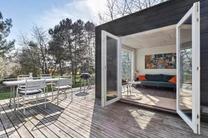 a house with a deck with a couch and a table at 1642-Hundested-Egernvej-1 in Hundested +18 photos