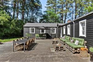 a patio with a green couch and a table and chairs at 1639-Frederiksvaerk-Genvejen-10 in Frederiksværk