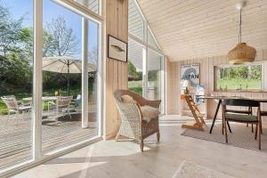 a screened in porch with a table and chairs at 1643-Hundested-Vaeselvaenget-3 in Hundested +14 photos